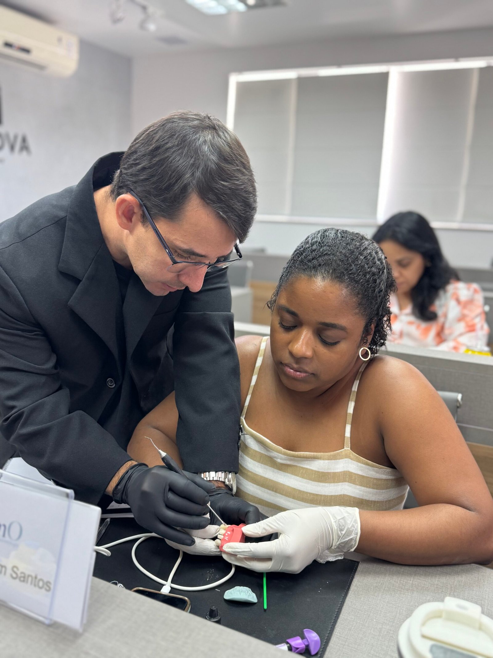Professor acompanhando aluna durante atividade prática em curso da Daimo Imersões